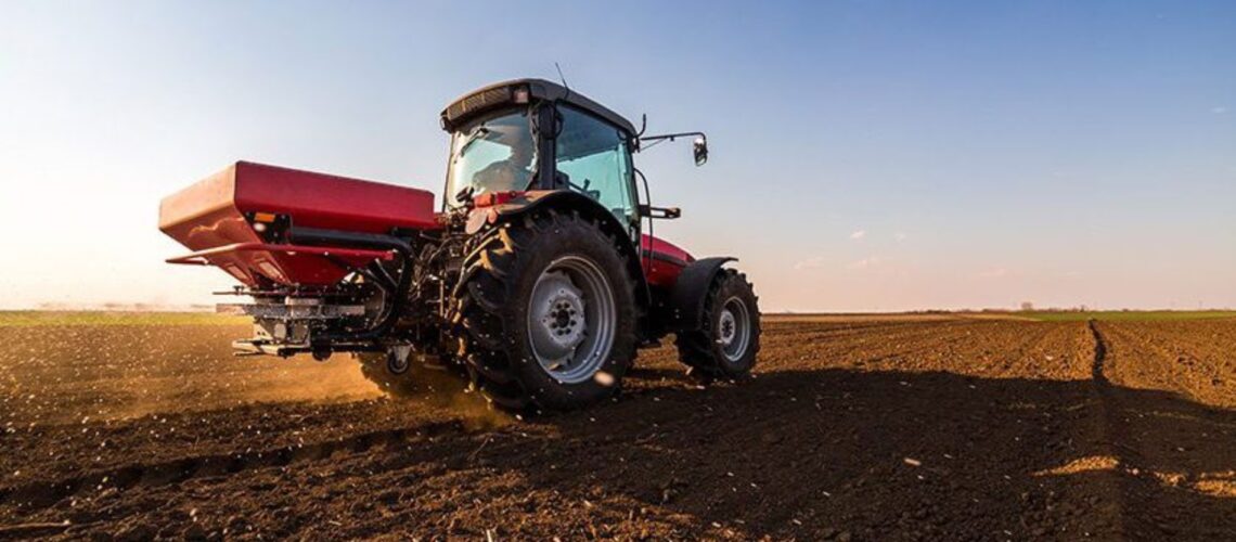 A tractor spreading fertilizer in a field.