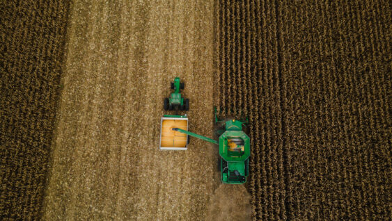 Aerial view of a combine during corn harvest, highlighting nutrient removal from the field and fertilizer planning needs.