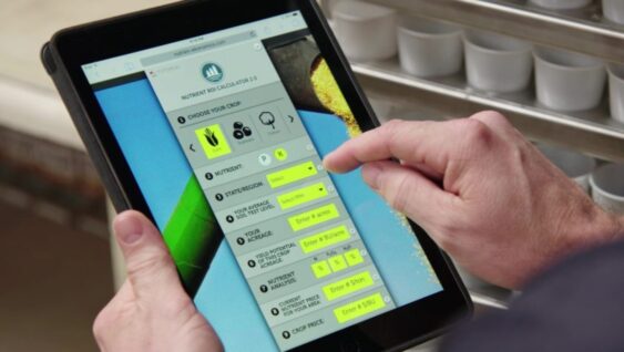An agronomist's hands using an ROI calculator.