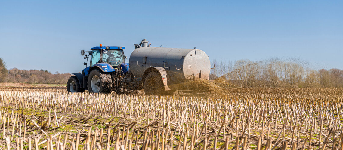 A tractor with slurry tanker fertilizing in the field.