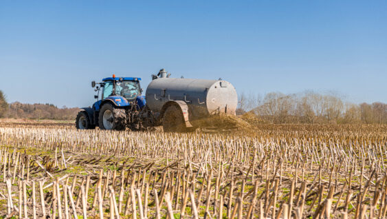 A tractor with slurry tanker fertilizing in the field.