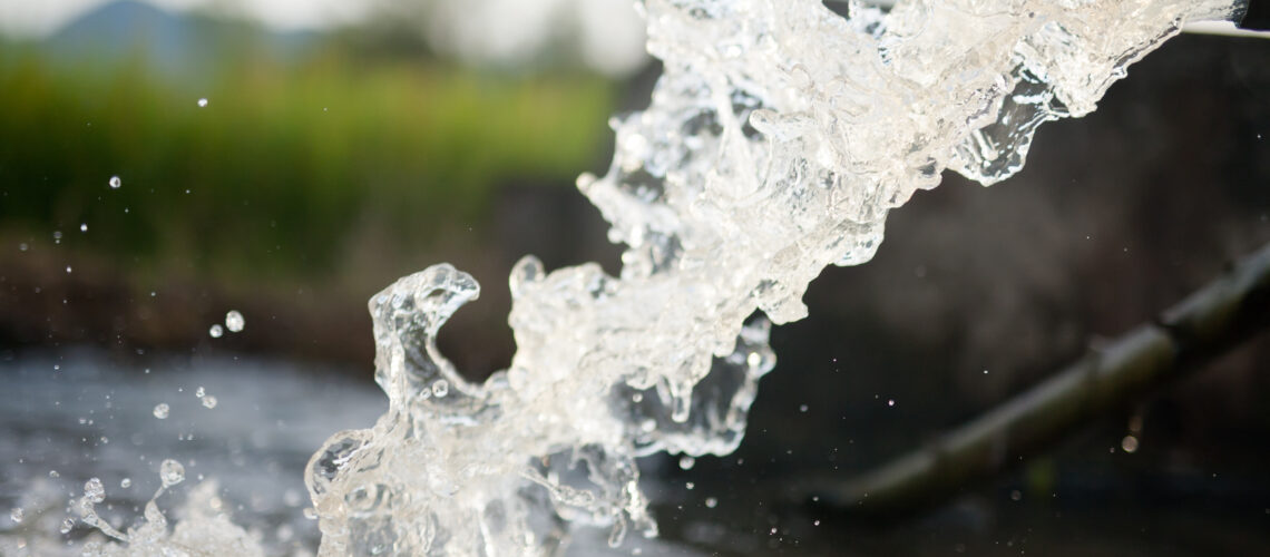 Clean water rushing out from a public irrigation pipe for agriculture use.