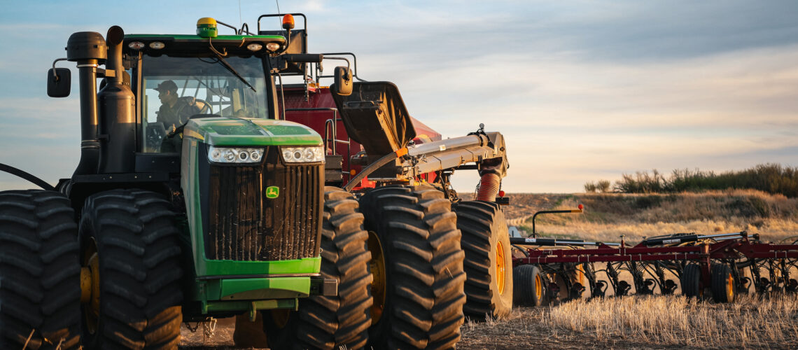 tractor spreading dry fertilizer on farm land