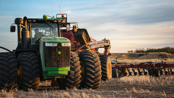 tractor spreading dry fertilizer on farm land