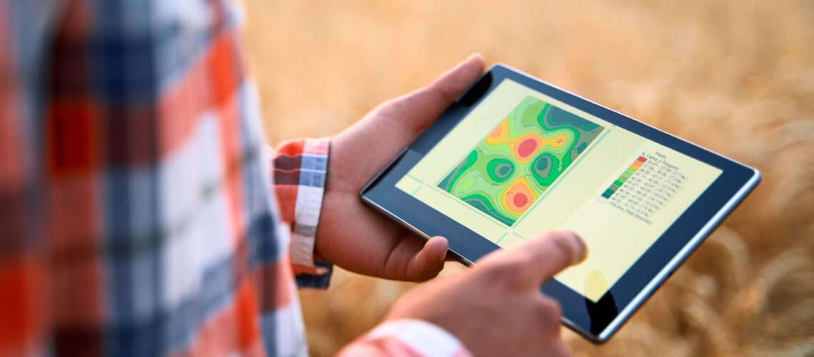 Farmer hands hold tablet using online data management software, differential fertilizer application maps. Agronomist works with touch screen to control, analyse agriculture business. Precision farming