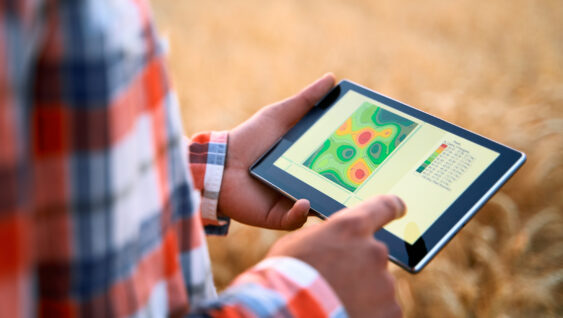 Farmer hands hold tablet using online data management software, differential fertilizer application maps. Agronomist works with touch screen to control, analyse agriculture business. Precision farming