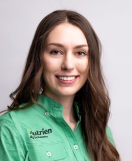 Photo of Stacie Yaremko in a green Nutrien Ag Solutions shirt in front of a grey backdrop.